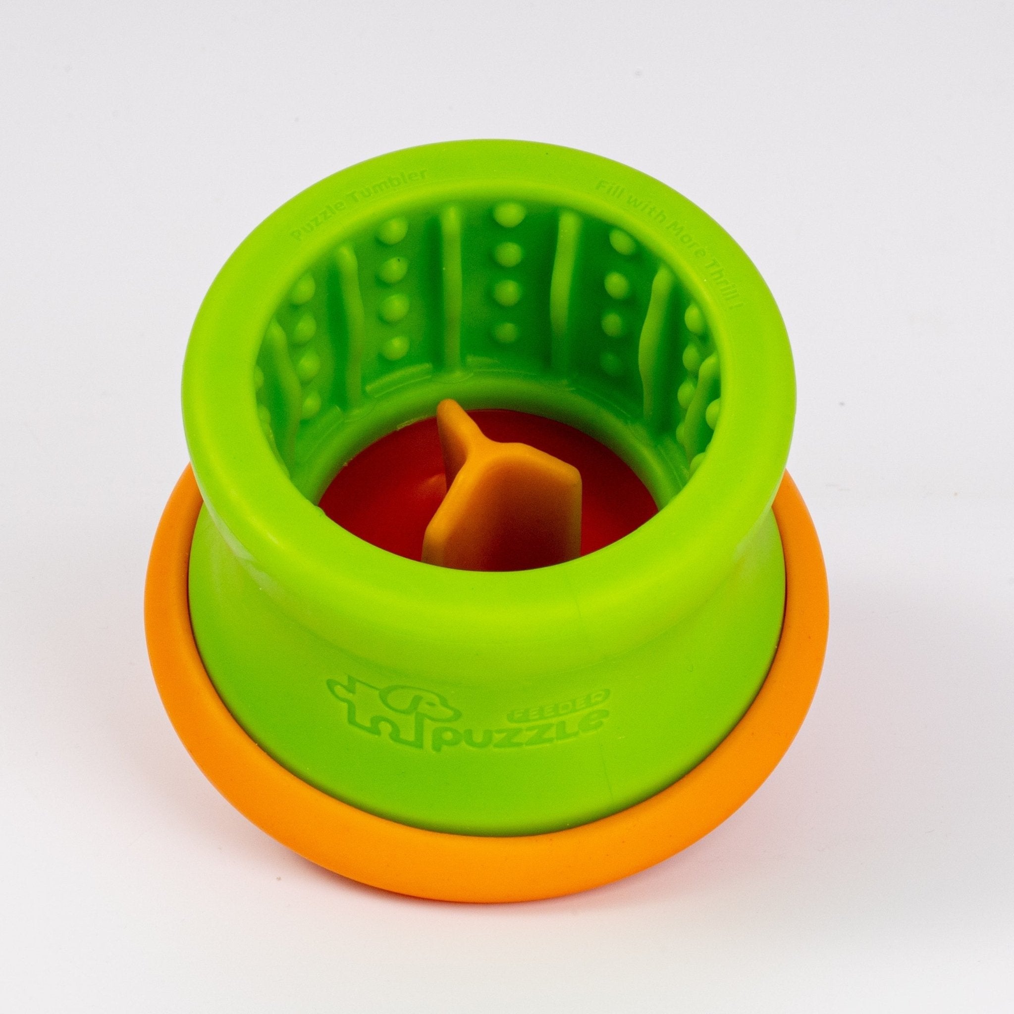 The Dog Puzzle Tumbler M from Puzzle Feeder™, designed for small to medium breeds, is a green and orange cylindrical enrichment toy made from eco-friendly OBP. It features raised bumps and a movable part inside to stimulate your dog's mind. Dishwasher-safe for effortless cleaning, it turns mealtime into an engaging activity.