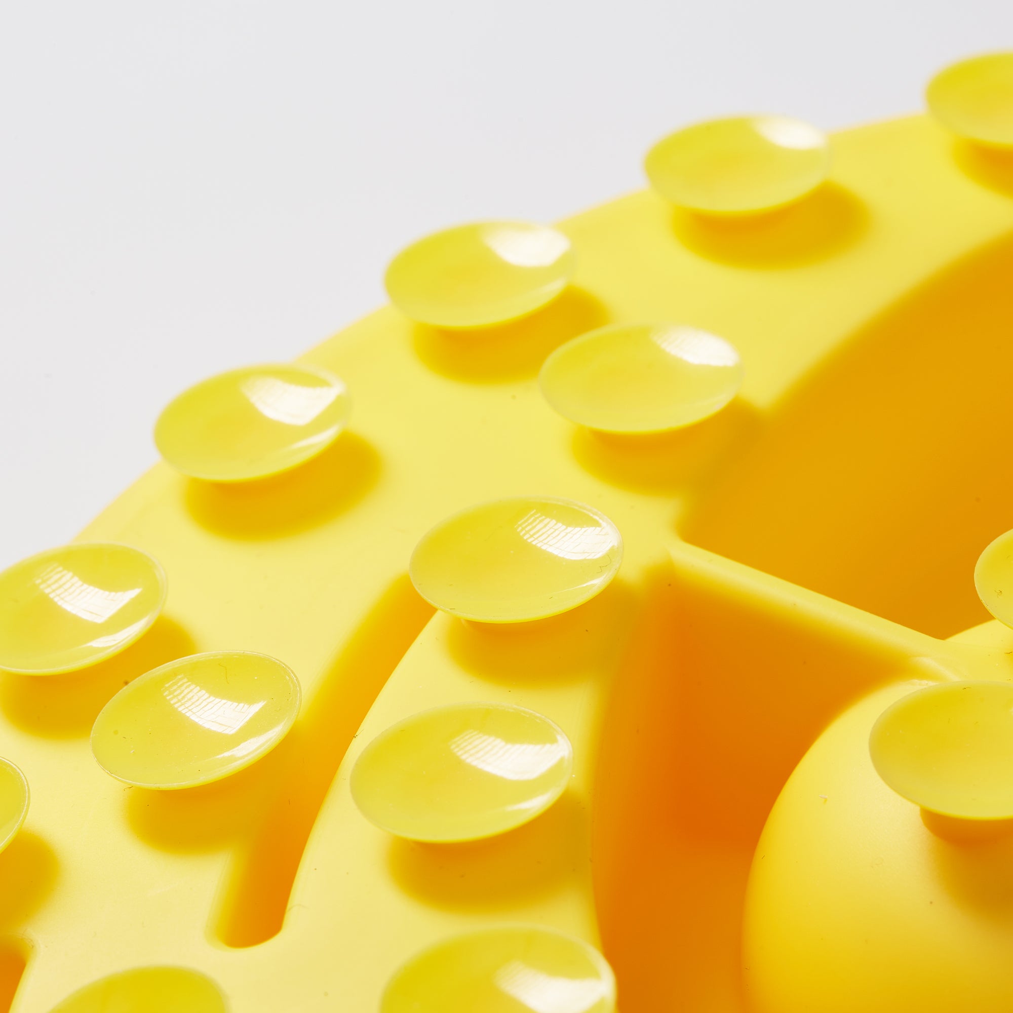 A close-up of the Puzzle Digger - For Cat Hunting Instinct (Wheat-Yellow) by Puzzle Feeder™, showcasing its biomimetic design pattern with suction cups.