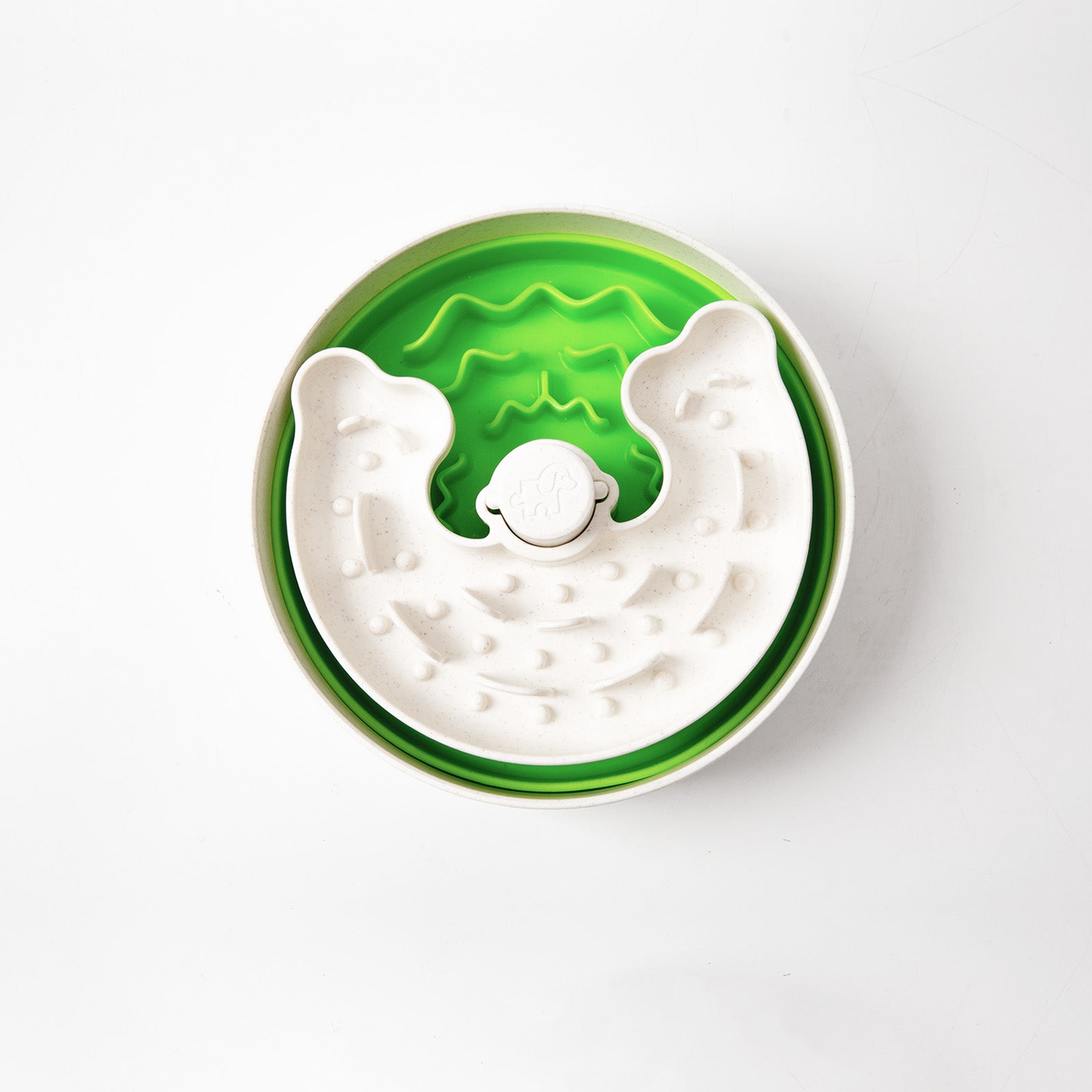 A round, white and green feeder bowl with raised sections to slow down eating.