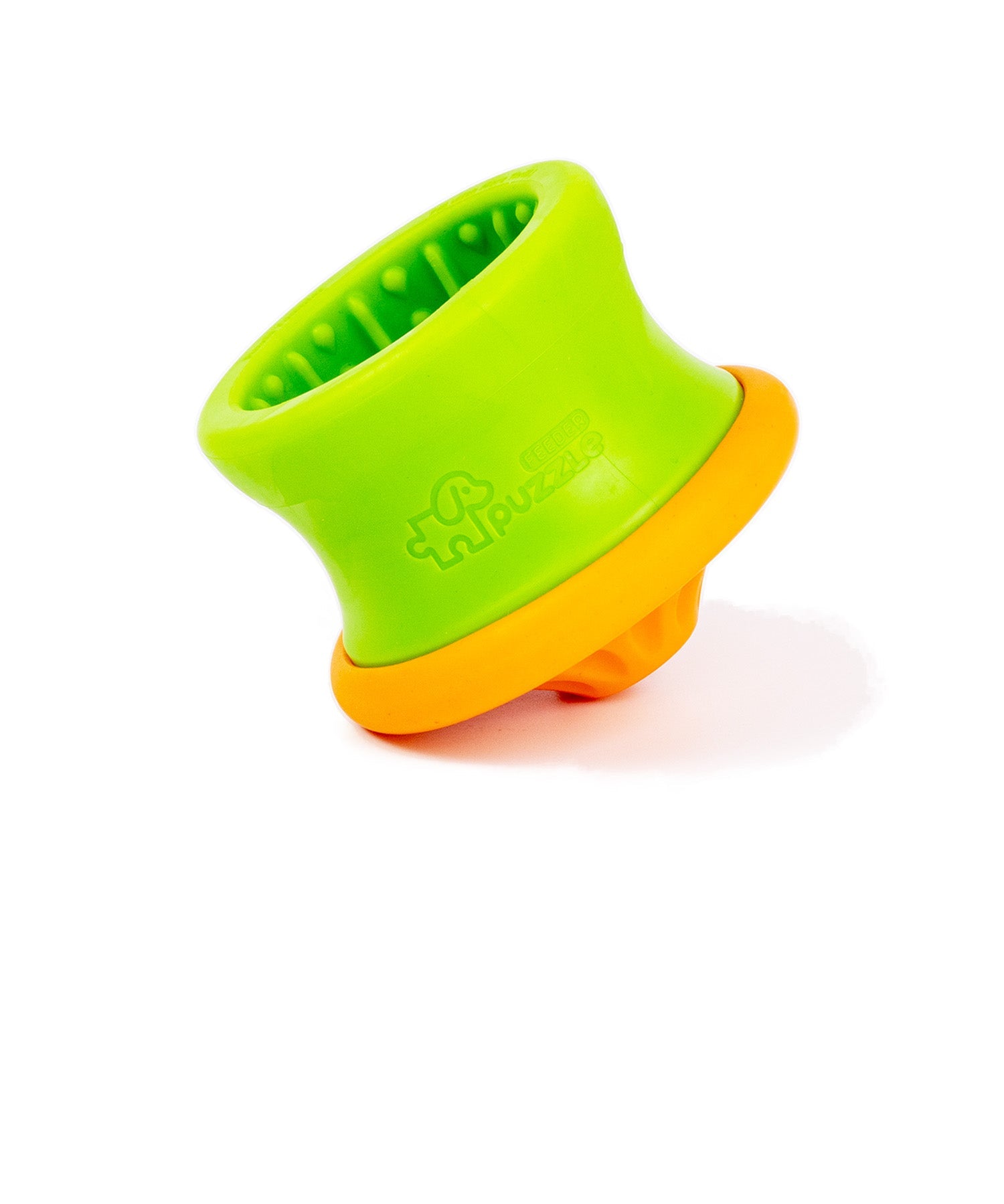 Two silicone feeders with round bases are placed on a wooden table. One feeder is pink with a blue base, and the other is green with an orange base. The feeders have a textured interior.