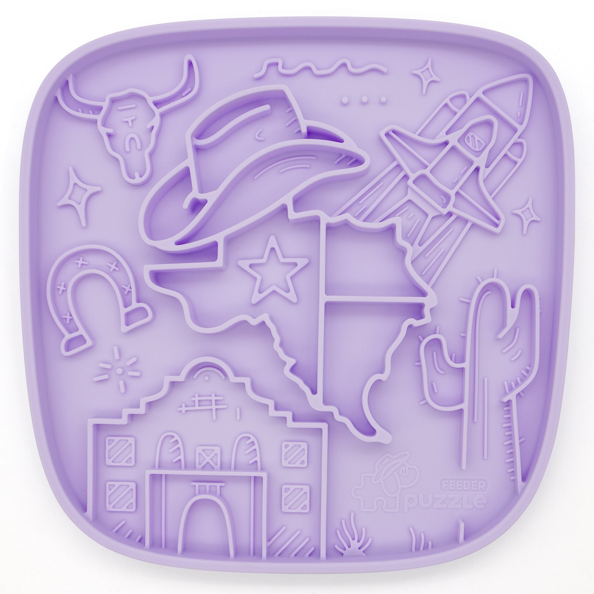 The Texas Themed Lick Mat by Puzzle Feeder™ is a purple silicone mat featuring cowboy hat, rocket, state outline, longhorn skull, horseshoe, cactus, mission facade, and star motifs. It promotes healthy eating habits and relieves anxiety and stress.