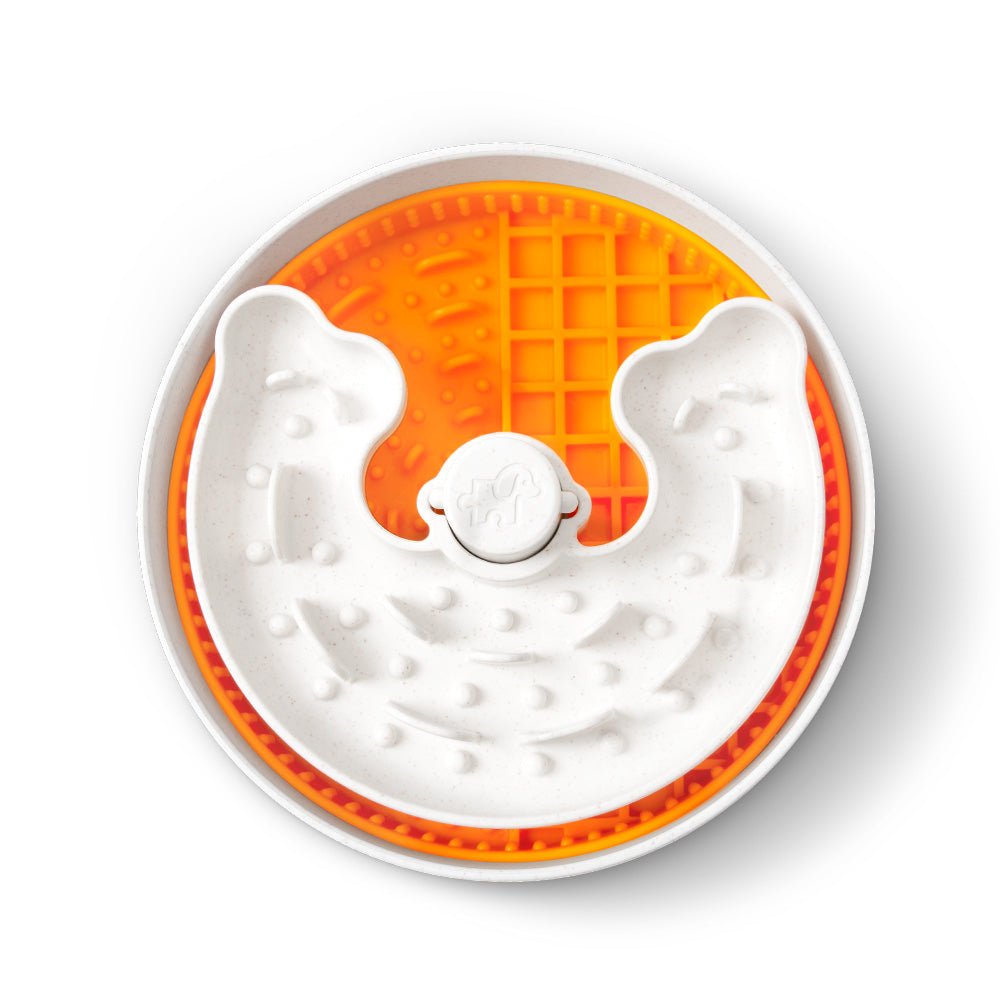 Top view of the Dog Puzzle Licker Junior by Puzzle Feeder™ in orange, featuring round design with raised patterns and interactive puzzle elements for an engaging mealtime experience, ideal for small to medium breeds.