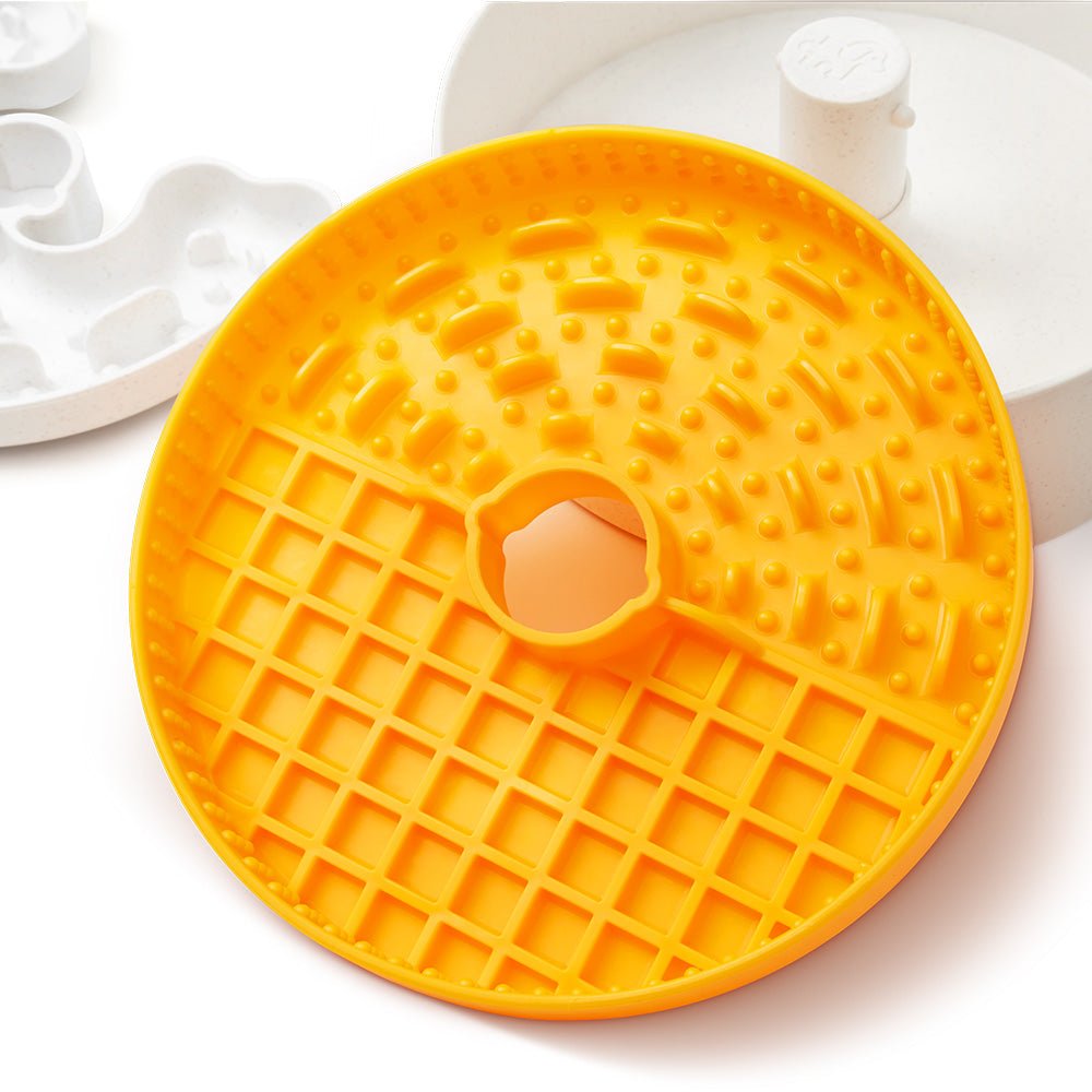 The Puzzle Feeder™ Dog Puzzle Licker Junior, designed for small to medium breeds, features an orange lick mat with triple textures and a central hole to slow down eating. Its compatibility with slow feeder dog bowls offers an interactive mealtime experience that challenges and entertains your pet.