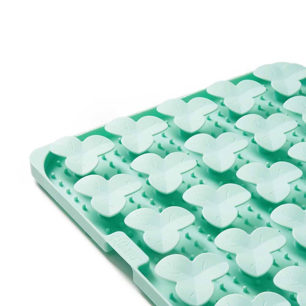 Close-up of the Dog Puzzle Mat - Slow Feeding Mat (Green) by Puzzle Feeder™, showcasing a textured silicone surface with a biomimetic design that includes leaf-like shapes and raised dots.