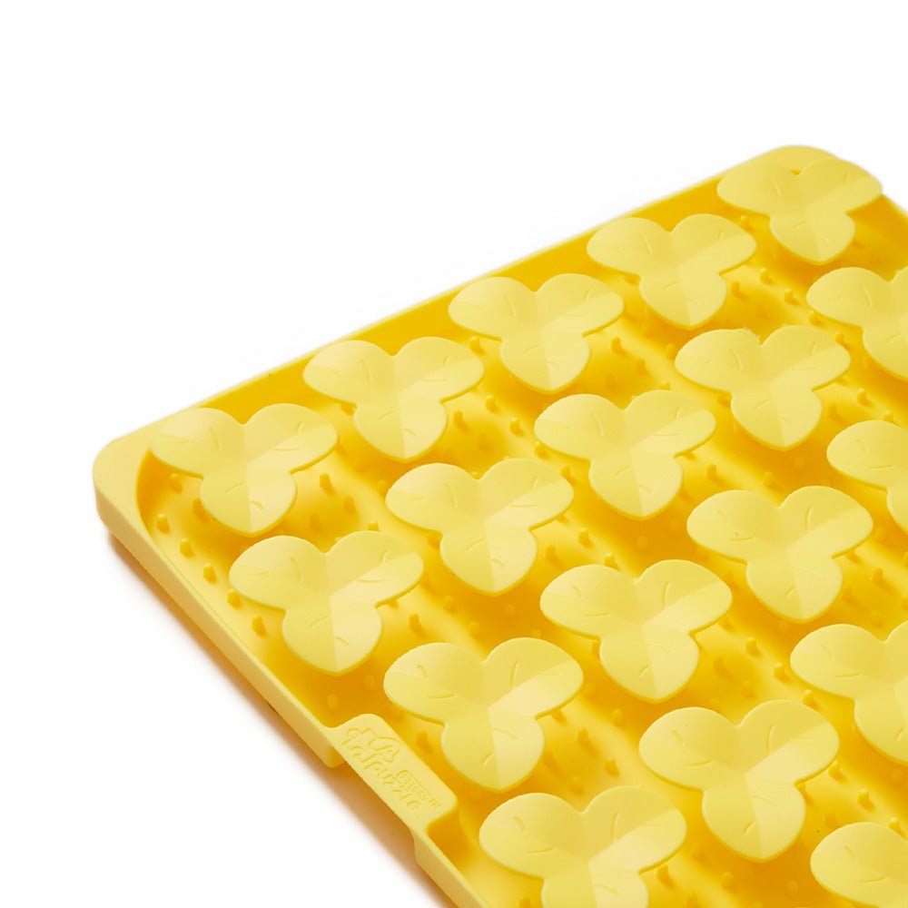 Puzzle Feeder™ presents the Dog Puzzle Mat - Slow Feeding Mat in yellow, designed with various butterfly-shaped cavities and featuring an anti-slip suction cup base for stable positioning during use.