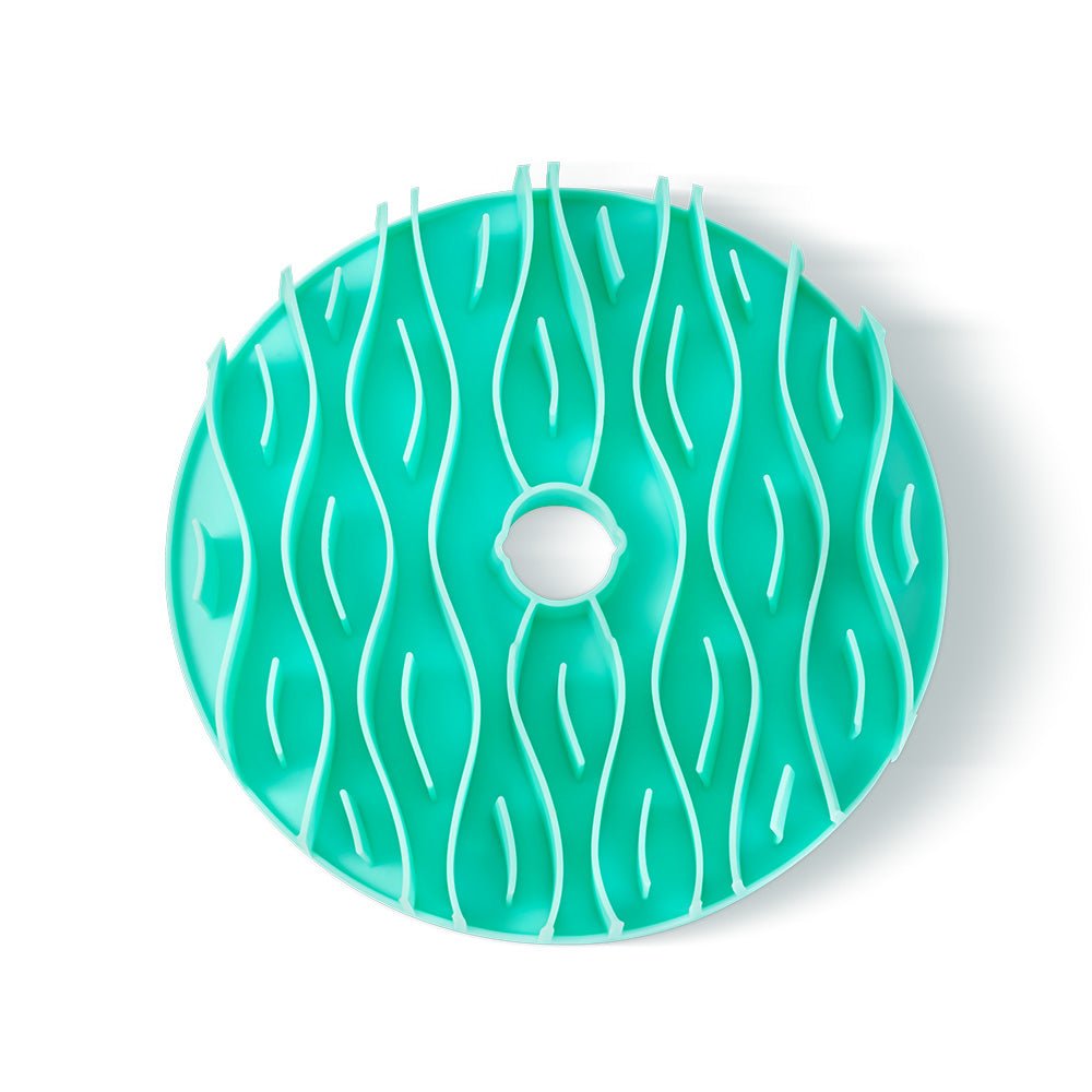 Introducing the Puzzle Feeder™ Dog Slowing Mat Accessory, a turquoise circular plastic mat with a textured wave design and central hole, specifically crafted to slow down your pet's eating.